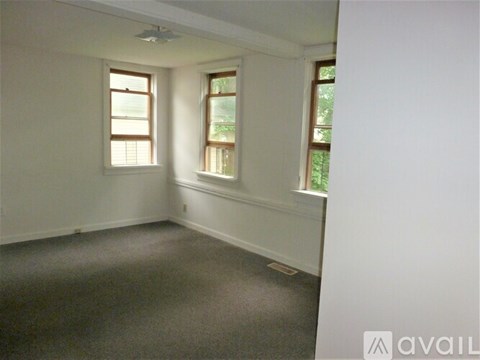 A room with two windows and a carpeted floor.