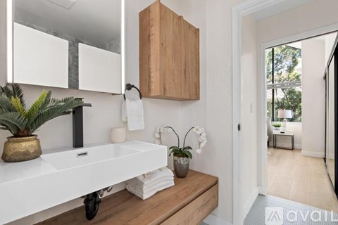 A bathroom with a white countertop and a wooden cabinet.