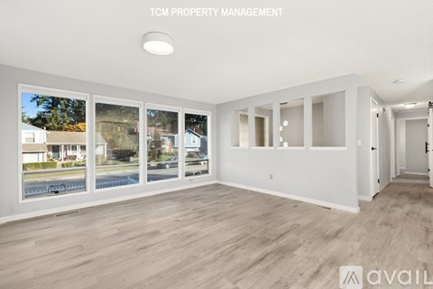 A spacious room with a view of the outside through the windows.