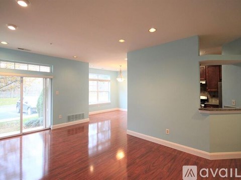 A spacious room with wooden floors and a large window.