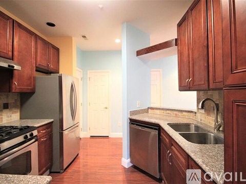 A kitchen with wooden cabinets and a refrigerator.