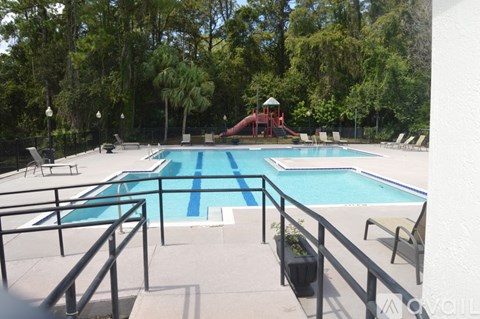 A pool with a slide and a fence.
