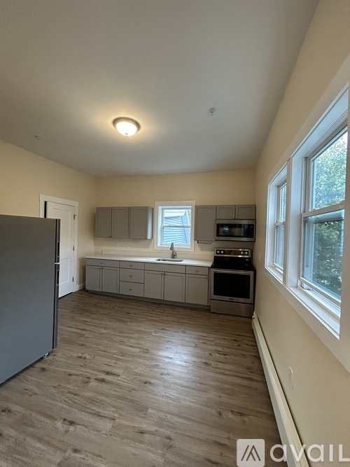 A kitchen with wooden floors and a refrigerator.