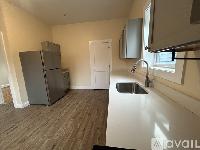 A kitchen with a sink and a refrigerator.