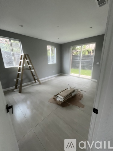 A room with a ladder and a box on the floor.