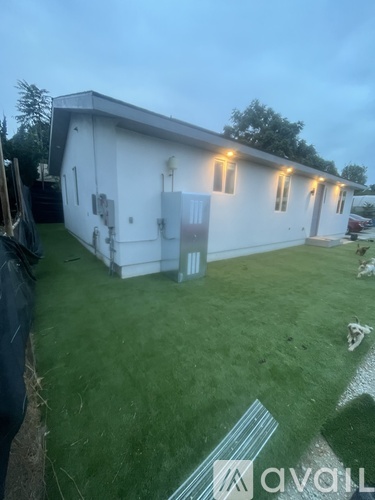 A white building with a grassy yard in front.