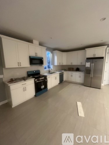 A kitchen with white cabinets and appliances.