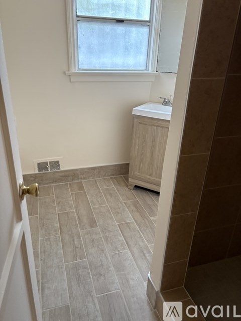 A bathroom with a tiled floor and a window.