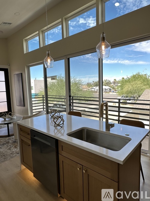 A kitchen with a large island and pendant lights.