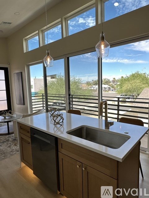 A kitchen with a large island and pendant lights.