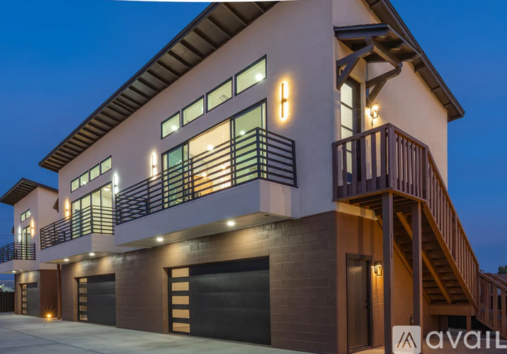 A modern house with a balcony and garage doors.