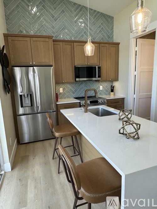 A kitchen with a white counter top and brown chairs.