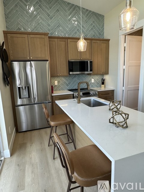 A kitchen with a white counter top and brown chairs.