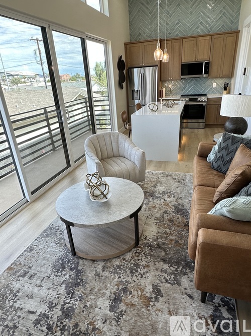 A living room with a white chair and a round table with a metal object on it.