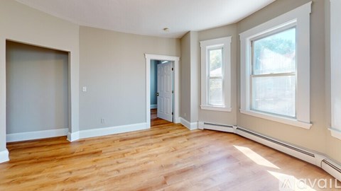 A spacious room with hardwood floors and a large window.