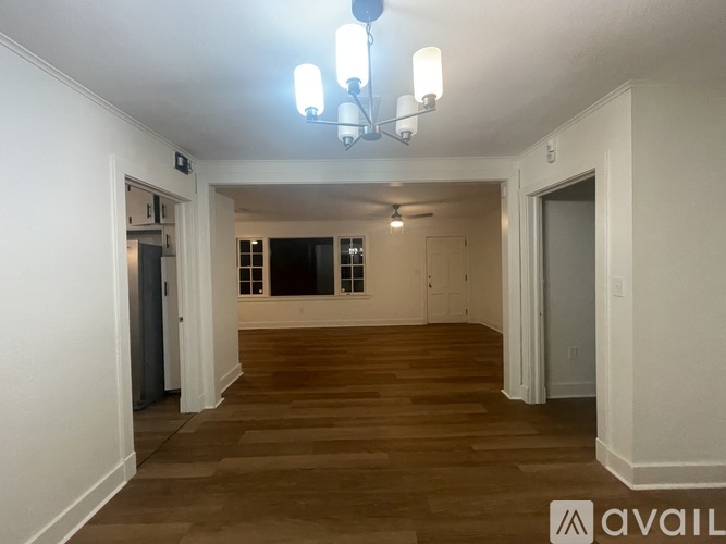 A room with wooden floors and a chandelier.