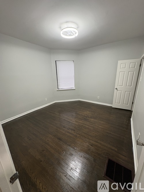 A room with wooden flooring and a white door.