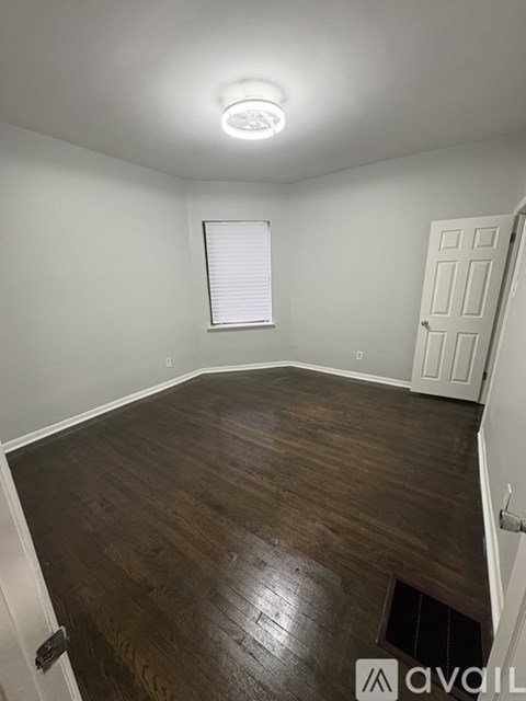 A room with wooden flooring and a white door.