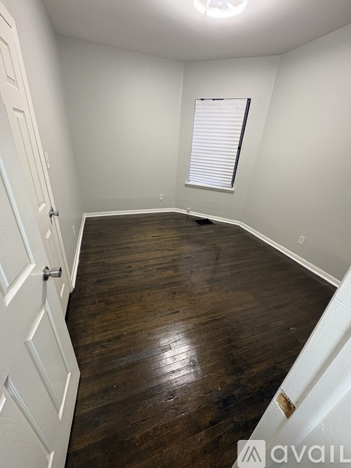 A room with wooden flooring and a white door.