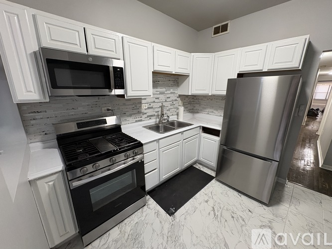 A kitchen with white cabinets and a black stove top oven.
