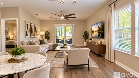 A well-lit living room with a dining table and chairs.