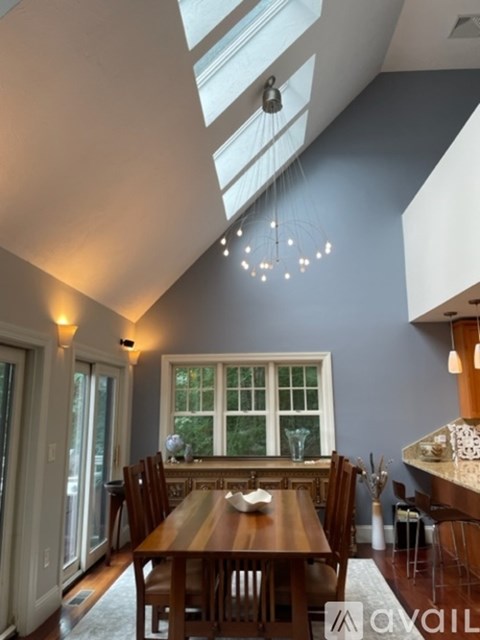 A dining room with a wooden table and chairs.