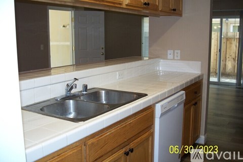 A kitchen with a white counter top and a dishwasher.