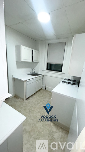 A small, white kitchen with a window and a sink.