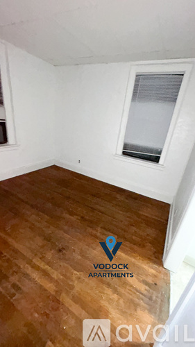 A room with wooden flooring and a window is available for rent.