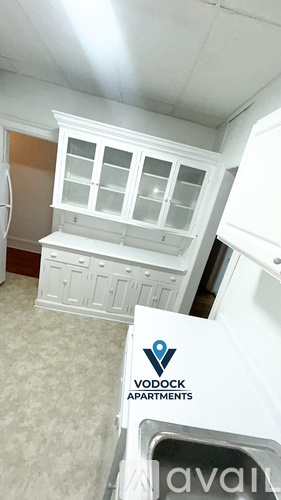 A sign for Vodock Apartments is in the foreground of a kitchen.