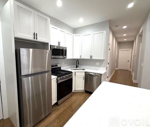 A kitchen with white cabinets and stainless steel appliances.