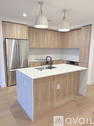 A kitchen with a white island and wooden cabinets.