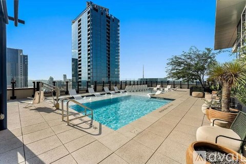 A pool area with a tall building in the background.