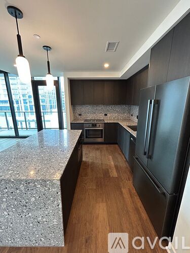 A modern kitchen with dark wood cabinets and a granite countertop.