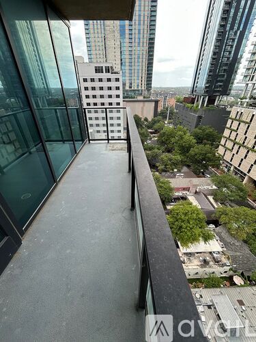 A balcony overlooks a cityscape with buildings and greenery.
