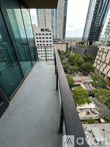A balcony overlooks a cityscape with buildings and greenery.
