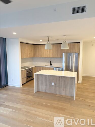 A modern kitchen with wooden cabinets and a central island.