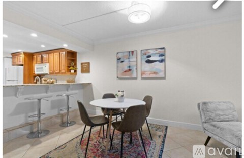 A dining area with a white table and chairs.