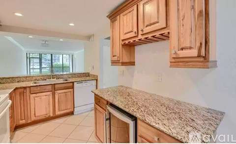 A kitchen with wooden cabinets and granite countertops.