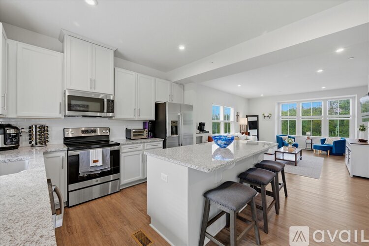A modern kitchen with white cabinets and stainless steel appliances.