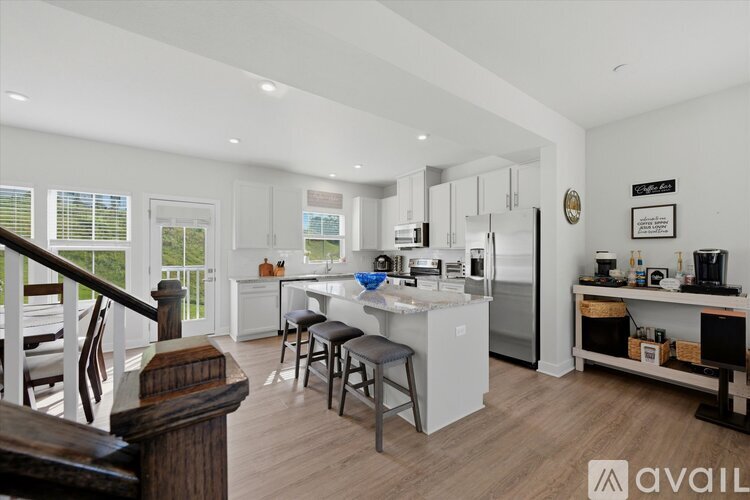 A kitchen with white cabinets and a refrigerator.