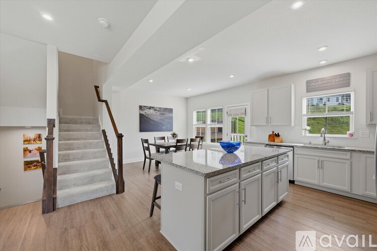 A modern kitchen with a dining area and a staircase.