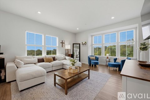 A living room with a white sofa set and a wooden coffee table.