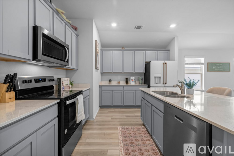 A kitchen with a black stove top oven and a black microwave above it.