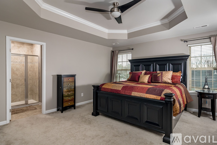 A bedroom with a bed, dresser, and ceiling fan.
