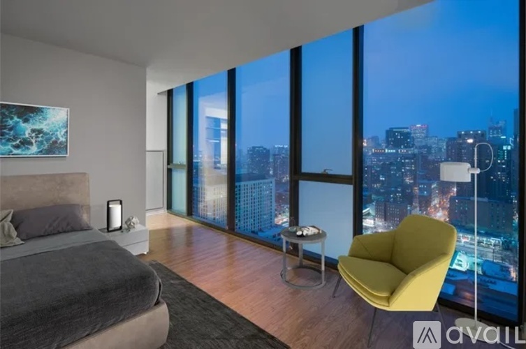 A bedroom with a large bed and a yellow chair.
