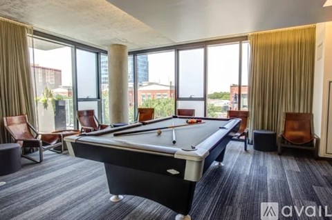 A pool table in a room with a view of the city.