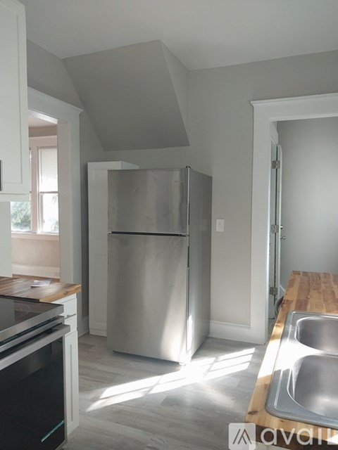 A kitchen with a stainless steel refrigerator and a wooden countertop.