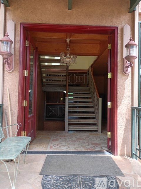 A staircase leads up to a chandelier in a building.