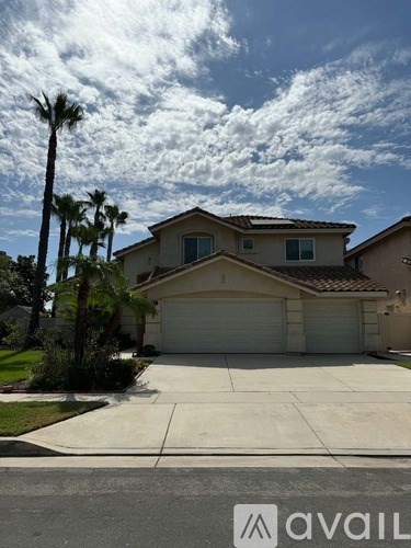 A house with a garage and palm trees in front.